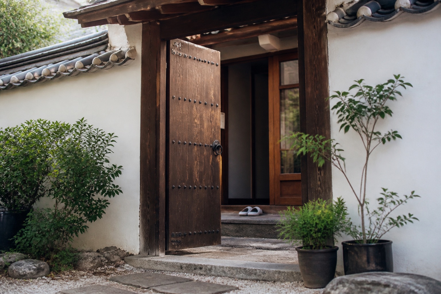 Open hanok gate with indoor slippers at the doorstep